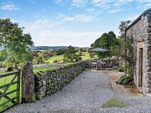 A stone wall leading to a stone building with a gravel path. - 2 Bed in Buxton (oc-54216) (Hartington)