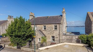 A stone building with a view of the sea, a paved area, and a fence. - 3 Bed in Brixham (oc-bx007) (Brixham)