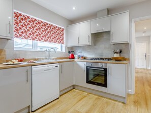 A modern kitchen with white cabinets, a dishwasher, a stove, and an oven. - 3 Bed in Brixham (oc-bx002) (Brixham)