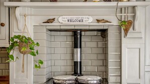 Una cucina con una parete piastrellata bianca, un piano cottura nero e un cartello di benvenuto sopra il piano cottura.