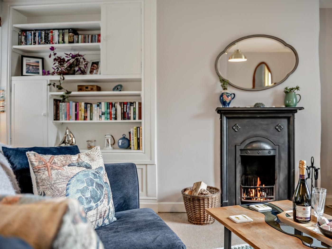 A living room with a fireplace, bookshelves, and a coffee table.