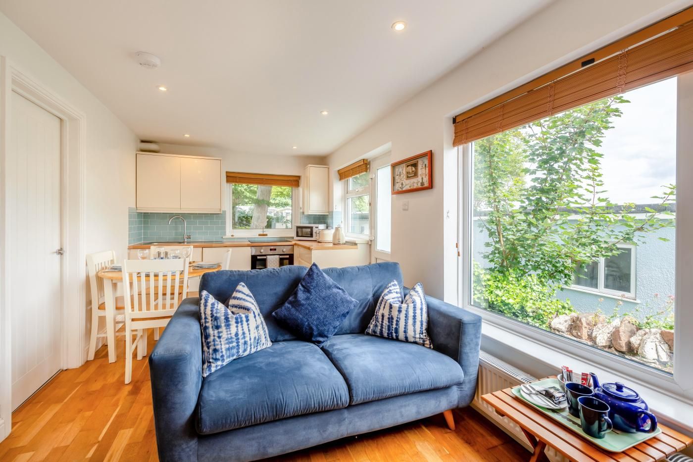 A compact living space with a sofa, dining table, and kitchenette.