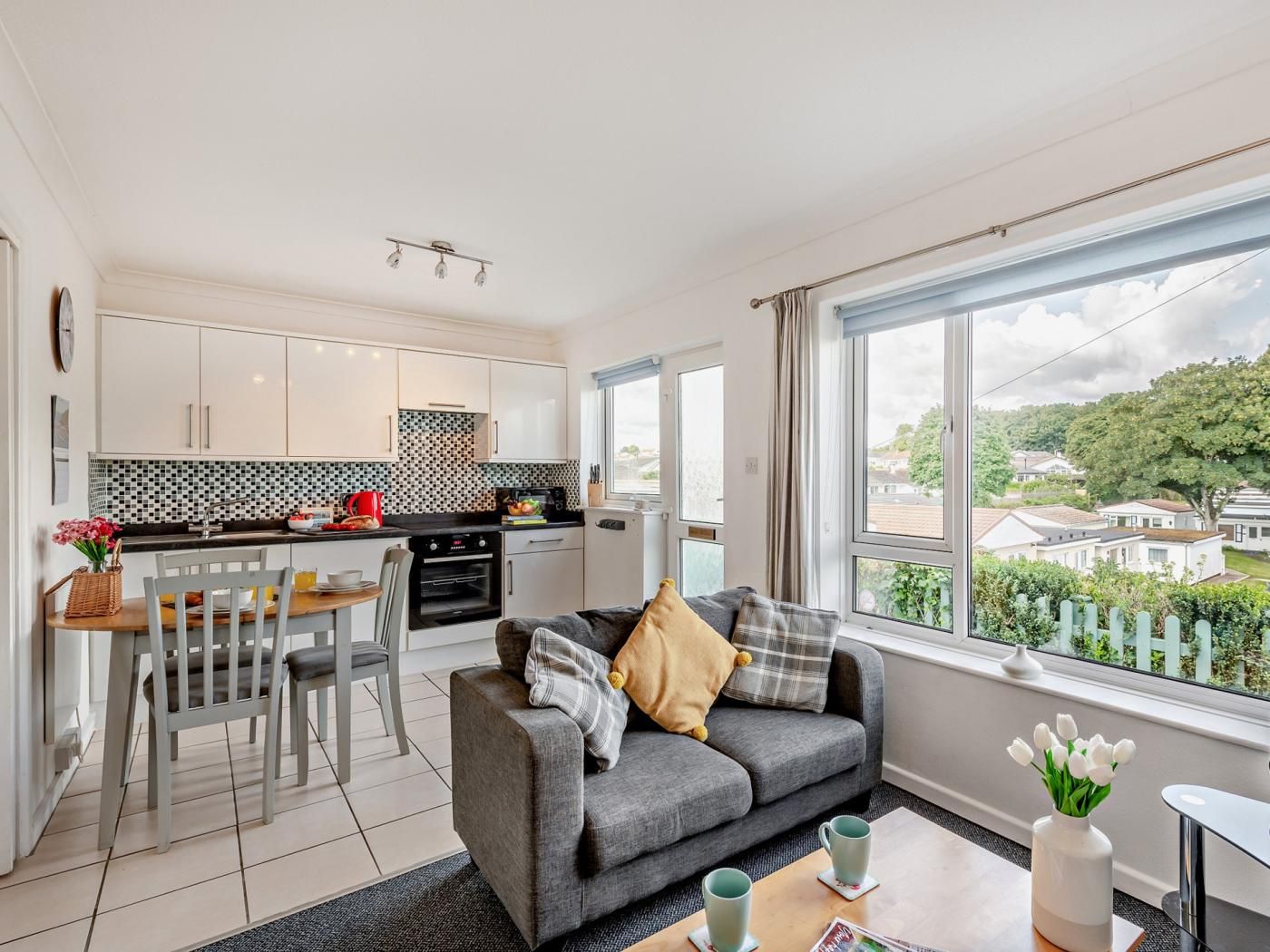 A compact living space with a kitchenette, a dining area, and a seating area with a view.
