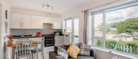 A compact living space with a kitchenette, a dining area, and a seating area with a view.