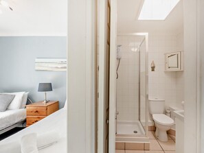 A bedroom with a bed, nightstand, lamp, and a wall-mounted artwork. - 2 Bed in Brixham (oc-bx079) (Brixham)