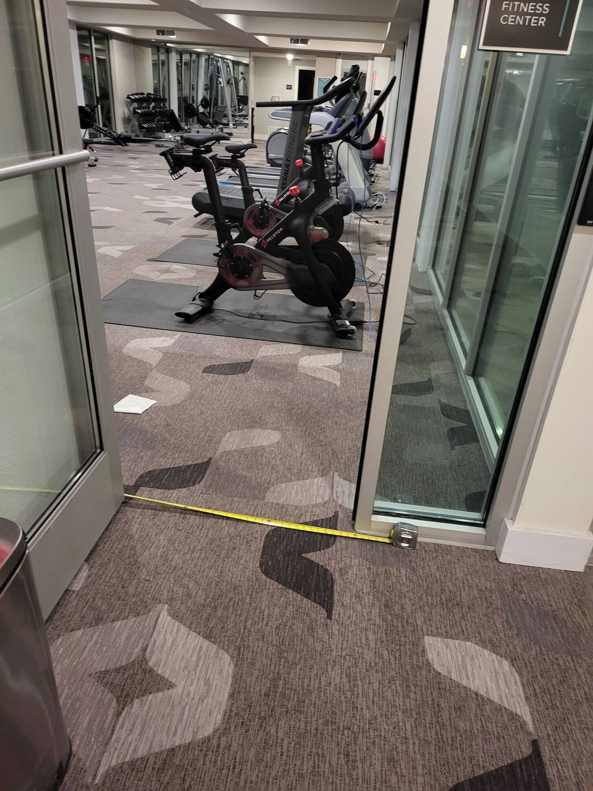 Ein Fitnessstudio mit Trainingsgeräten, darunter Lauf- und Ergometer.