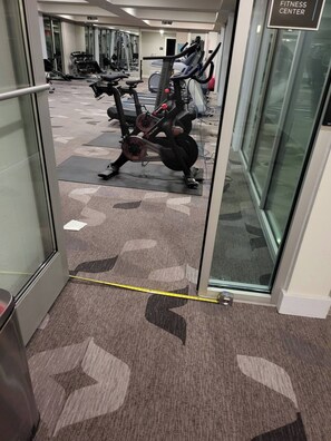 Un gimnasio con equipo de ejercicios, incluyendo bicicletas estáticas y cintas de correr.