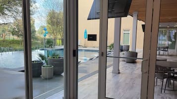 Ein modernes Interieur mit großen Schiebeglastüren, die zu einem Außenpoolbereich führen.