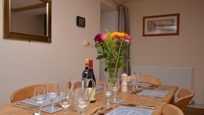 A dining table set with wine glasses, plates, cutlery, and a bottle of wine. - 3 Bed in Wells (oc-55232) (Green Ore)
