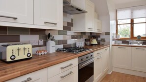A modern kitchen with white cabinets, a wooden countertop, a gas stove, and a built-in oven. - 2 Bed in Canterbury (oc-55811) (Waltham)