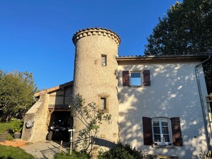 A stone tower attached to a building with a small window and a door. - Chambre d hôte en Drôme des collines (Saint-Laurent-d'Onay)