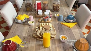 Une table à manger dressée avec différents plats, ustensiles et récipients.