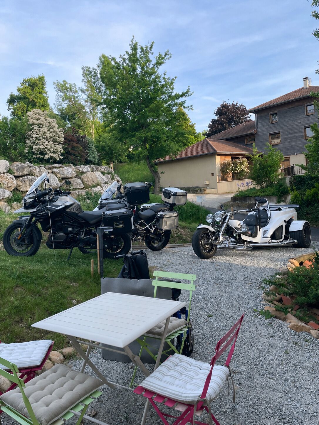 En grusvej med to motorcykler og et bord med stole.