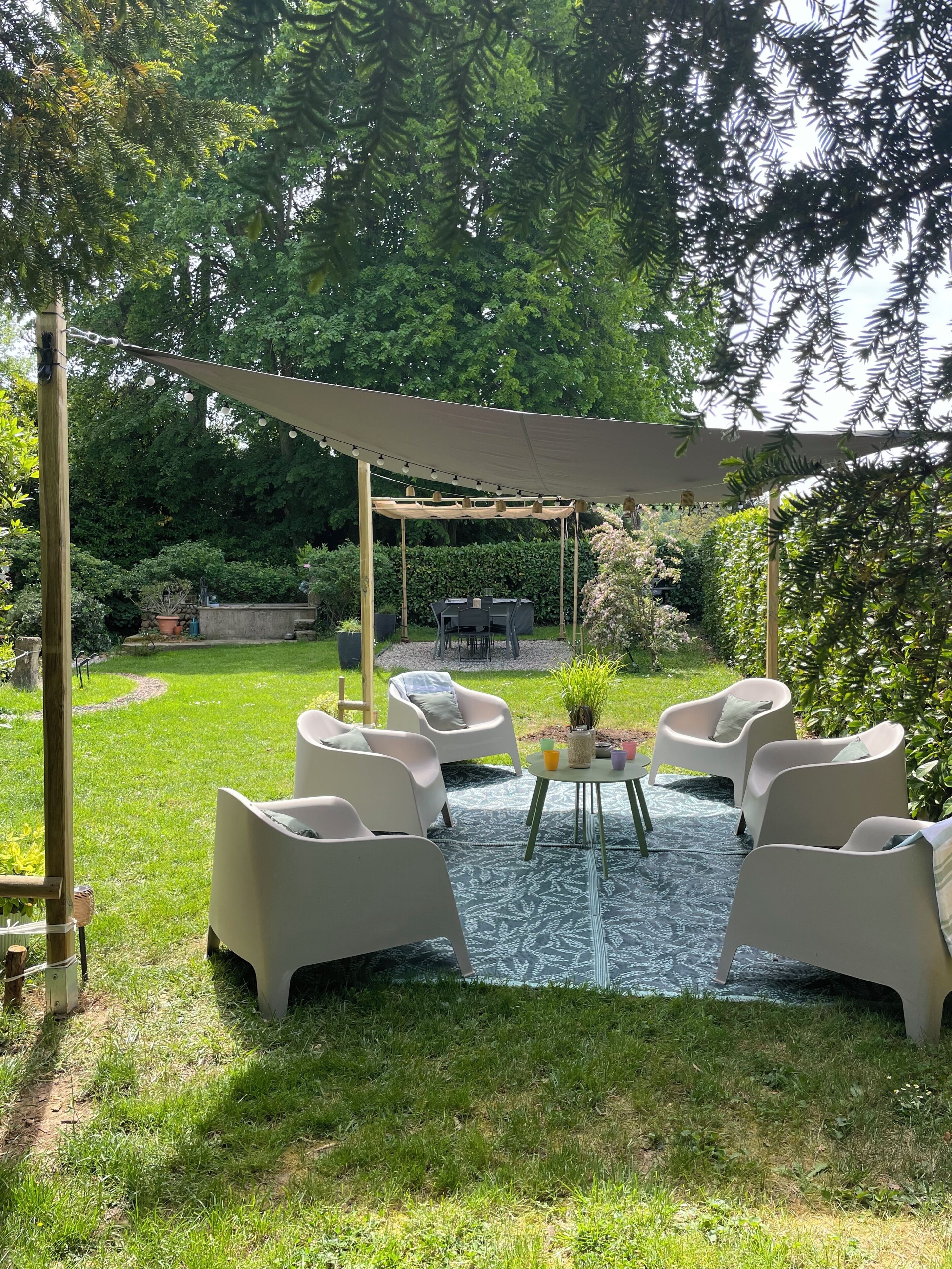 Un patio couvert avec des meubles d’extérieur, une pergola et un barbecue.