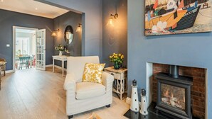Una sala de estar con chimenea, sofá, mesa de centro y un cuadro en la pared.