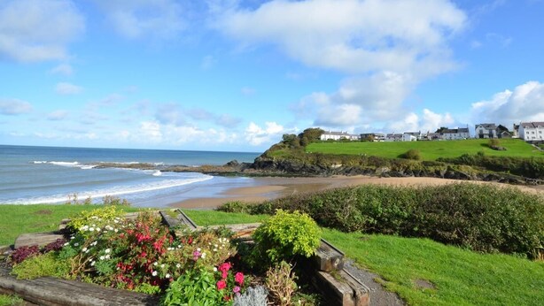 A coastal landscape with a grassy area, a wooden fence, and a view of the sea. - 3 Bed in Lampeter (oc-55308) (Ciliau Aeron)