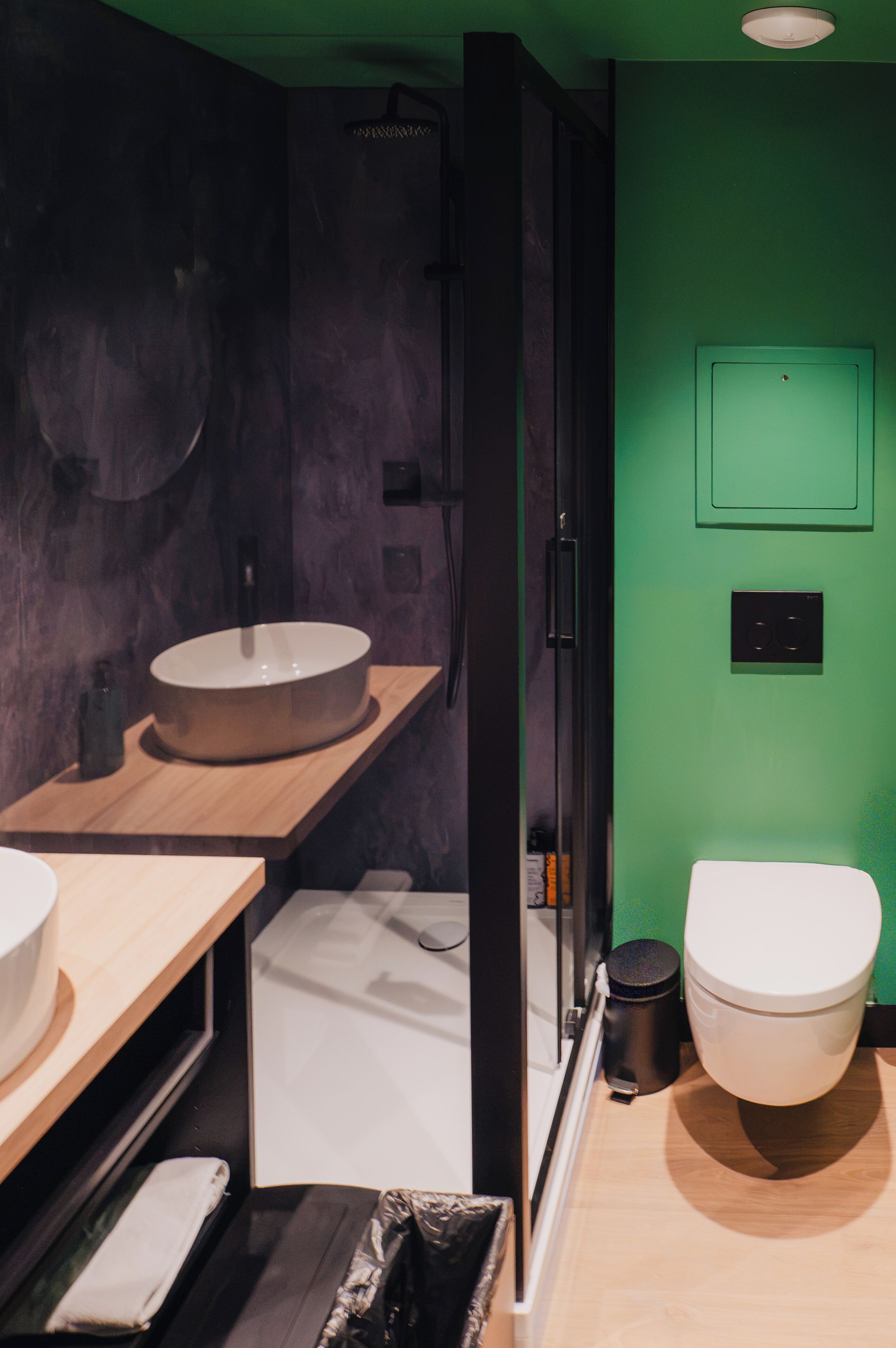 A modern bathroom with a round sink, a toilet, and a shower area.