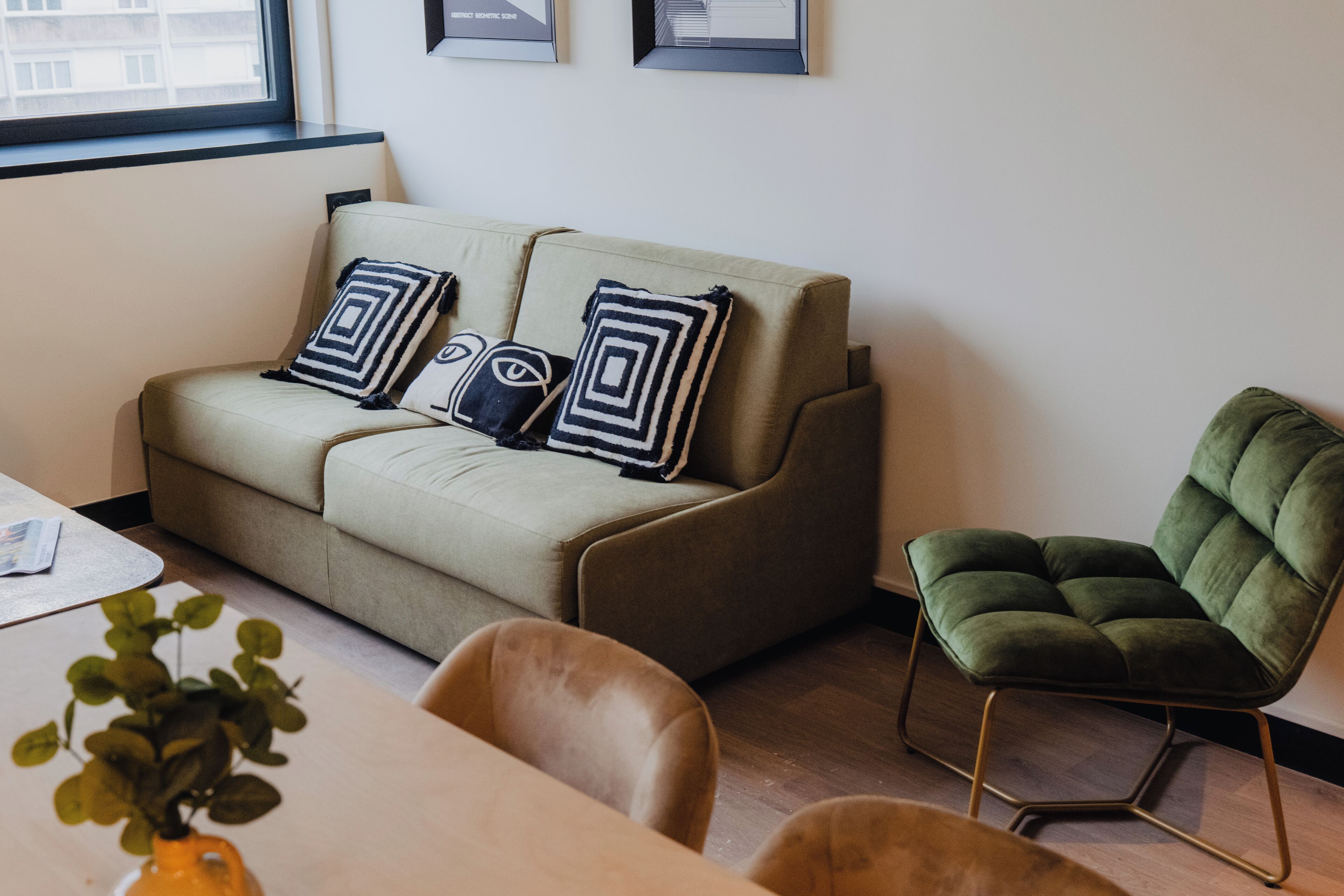 A modern living room with a sofa, a green armchair, and a coffee table.