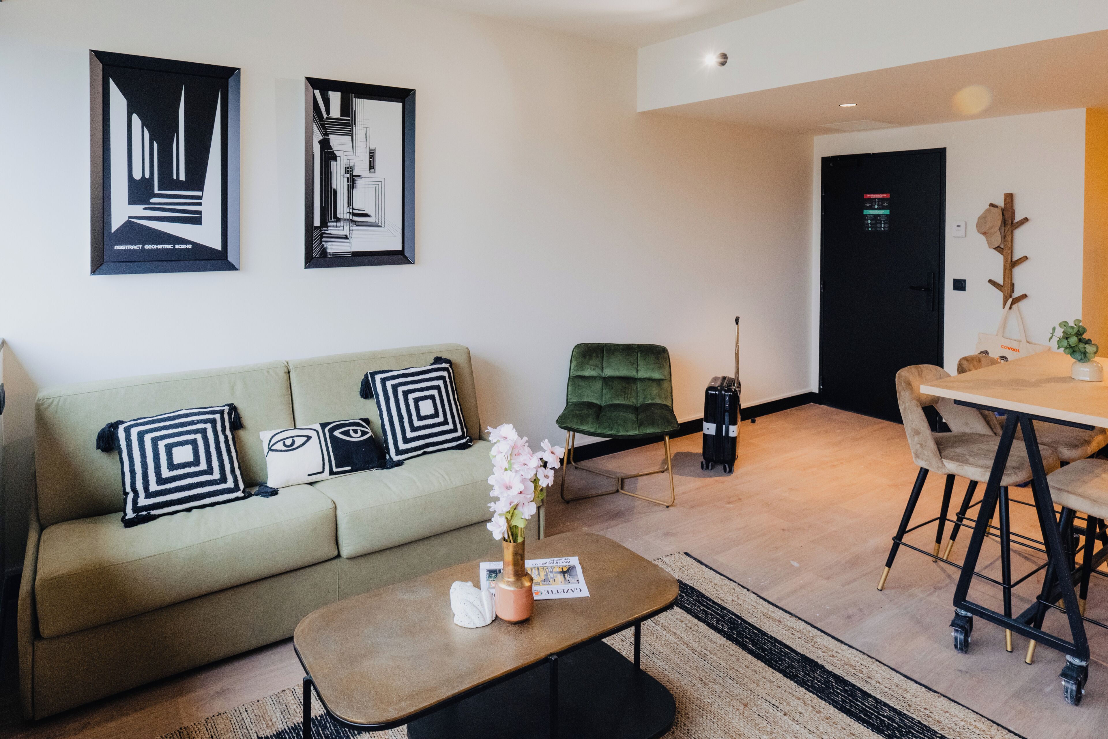 Een moderne woonkamer met een bank, salontafel en een eethoek met tafel en stoelen.