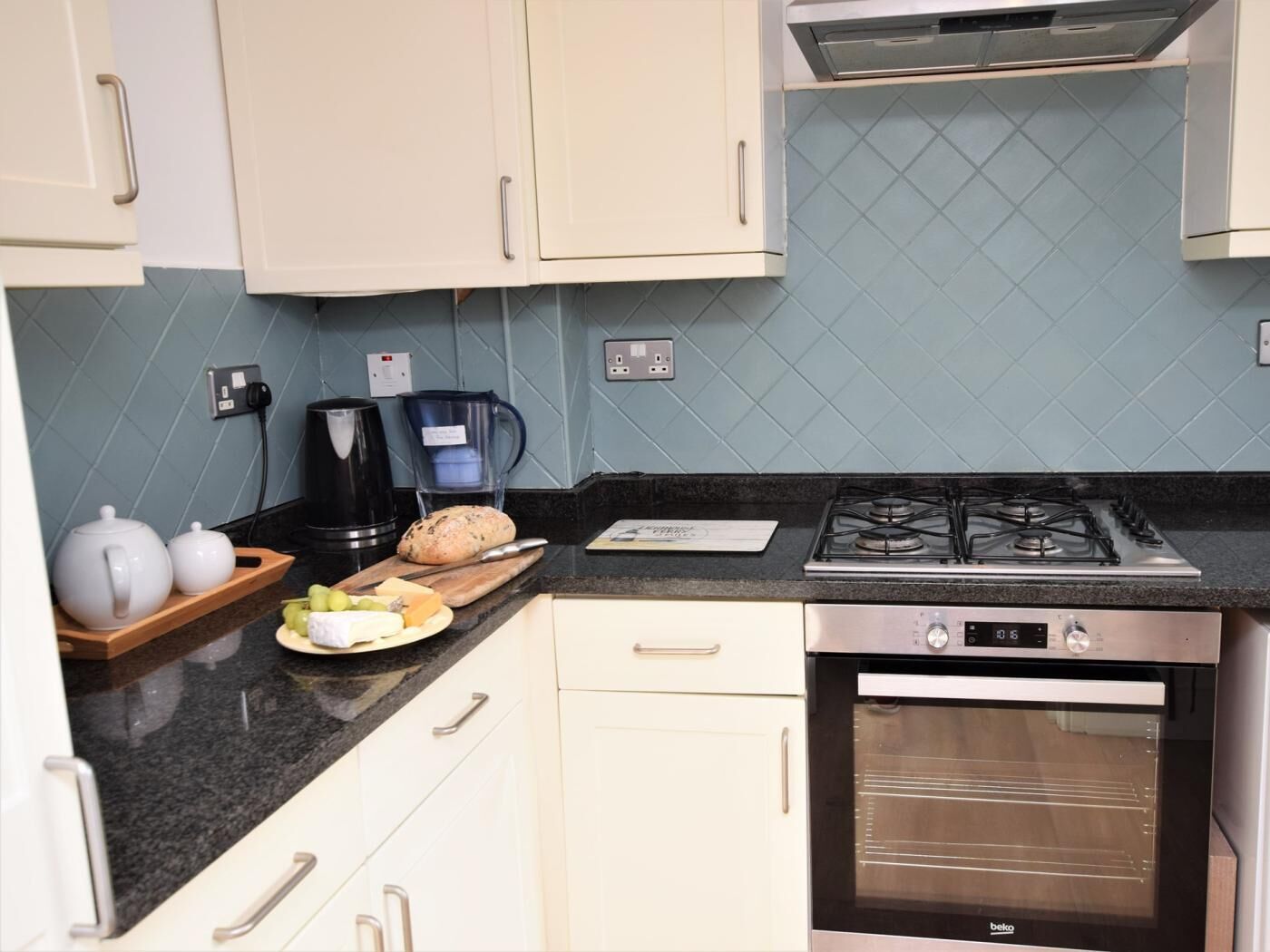 Een keuken met een gasfornuis, oven en koffiezetapparaat.