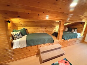 Ein Blockhaus-Interieur mit zwei Holzwetten, einer kleinen Bank und einer Holzziel.