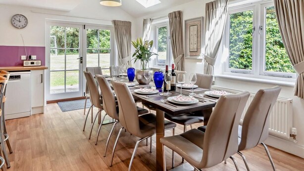 Un comedor con una mesa dispuesta para cuatro, sillas, una radio y vistas al exterior.