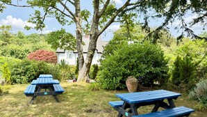 A garden with picnic tables and a large vase. - Alway at Lifton Hall (Lifton)