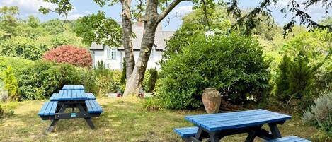 A garden with picnic tables and a large vase.