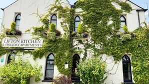 A building with a sign reading 'LIFTON KITCHEN & HOLIDAY APARTMENTS.' - Alway at Lifton Hall (Lifton)