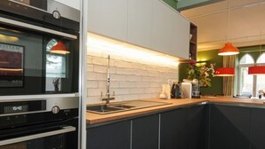 Una cocina moderna con horno empotrado, un lavamanos y una encimera.