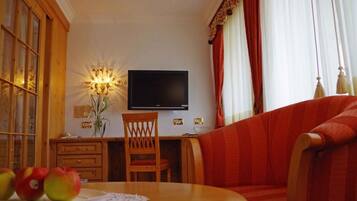 Suite Junior, balcone, vista giardino | Area soggiorno | TV a schermo piatto 42 pollici con canali satellitari