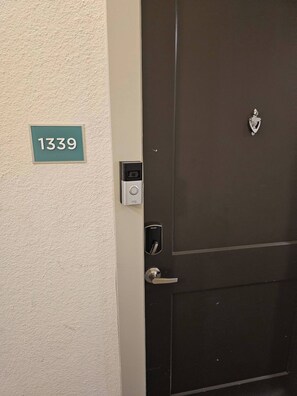 A door with a digital lock and a keypad, a doorbell, and a number plate '1339' on the wall. - Riverwalk Downtown Luxury Pool & Free Parking (San Antonio)