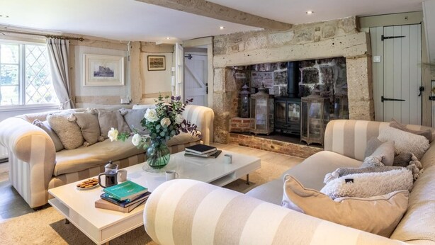 A cozy living room with a fireplace, sofas, a coffee table, and a bookshelf. - 6 Bed in Lymington (oc-56765) (Boldre)