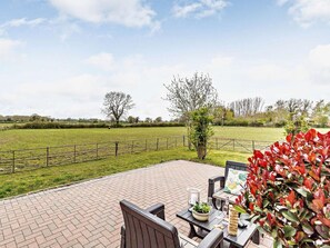 A patio with outdoor seating, a view of a grassy field, and a fence. - 2 Bed in Dereham (oc-57133) (Mattishall)