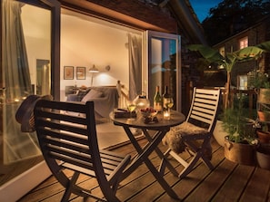 Un espace extérieur accueillant, aménagé avec une table, des chaises et des plantes en pot.