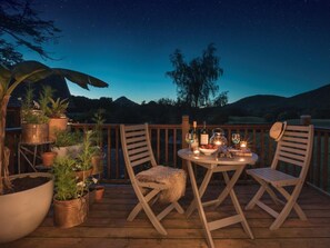 A wooden deck with two chairs, a table with drinks, and potted plants. - 1 Bed in Coniston (oc-lcc37) (Blawith)