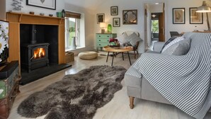 A cozy living room with a fireplace, a sofa, a coffee table, and a rug. - 1 Bed in Coniston (oc-lcc37) (Blawith)