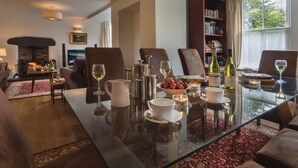 A cozy living room with a fireplace, a glass coffee table, comfortable seating, and a bookshelf. - 4 Bed in Nr Hawkshead (oc-lcc33) (Near Sawrey)