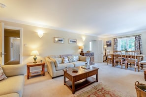 A living room with a sofa, coffee table, and a dining area with chairs and a table. - 2 Bed in Nr Kendal (oc-lcc35) (Crosthwaite)