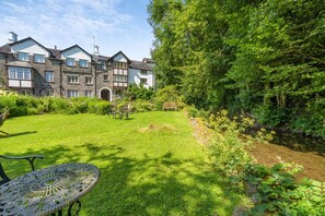 A large stone building with multiple windows and a well-maintained lawn. - 2 Bed in Nr Kendal (oc-lcc35) (Crosthwaite)