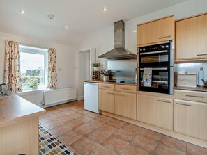 A modern kitchen with wooden cabinets, a built-in oven, and a dishwasher.