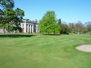 A golf course with a building in the background. - 2 Bed in Dundee (oc-58026) (Wellbank)