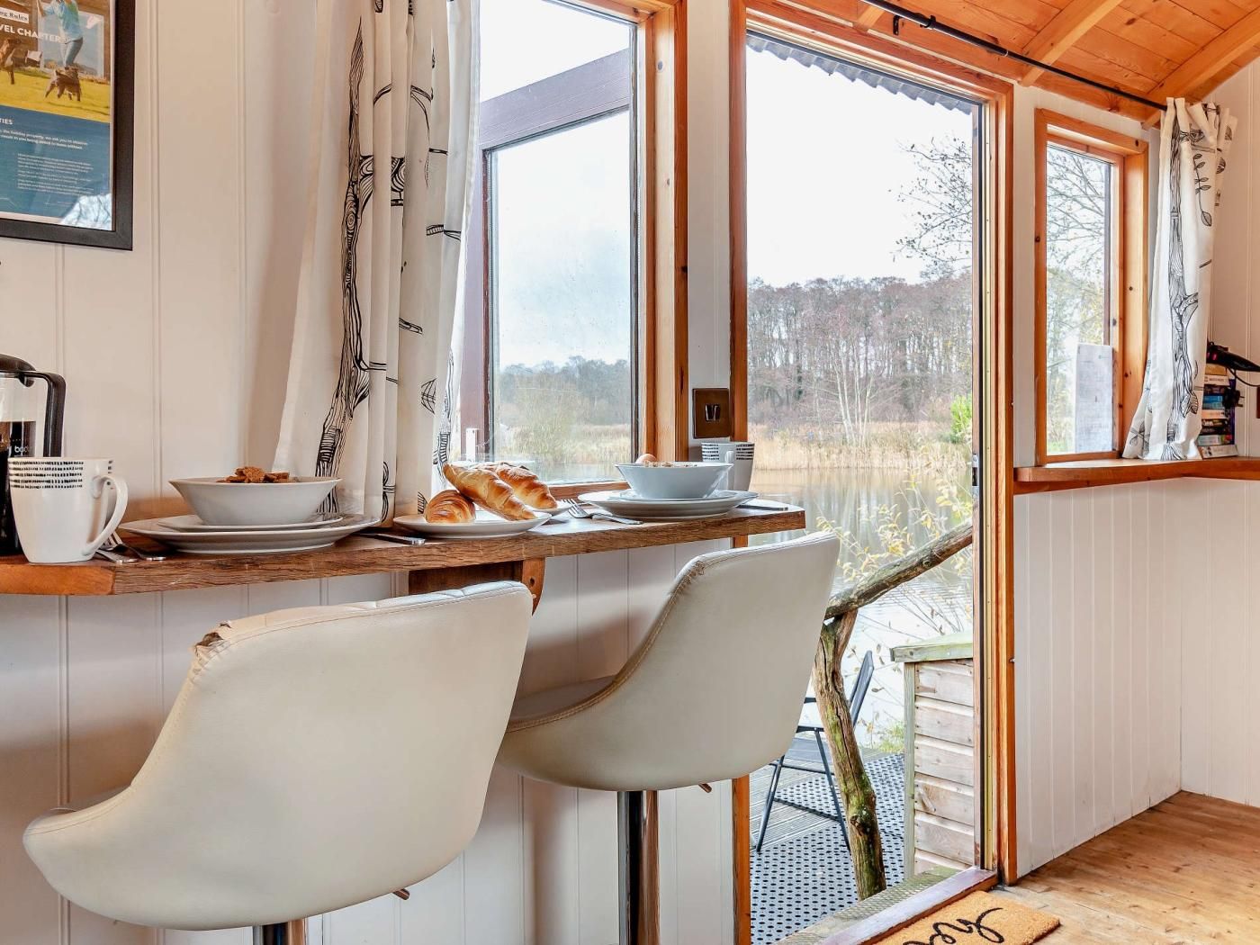Een eethoek met een houten tafel, twee stoelen, een kom met eten en een bord met brood.
