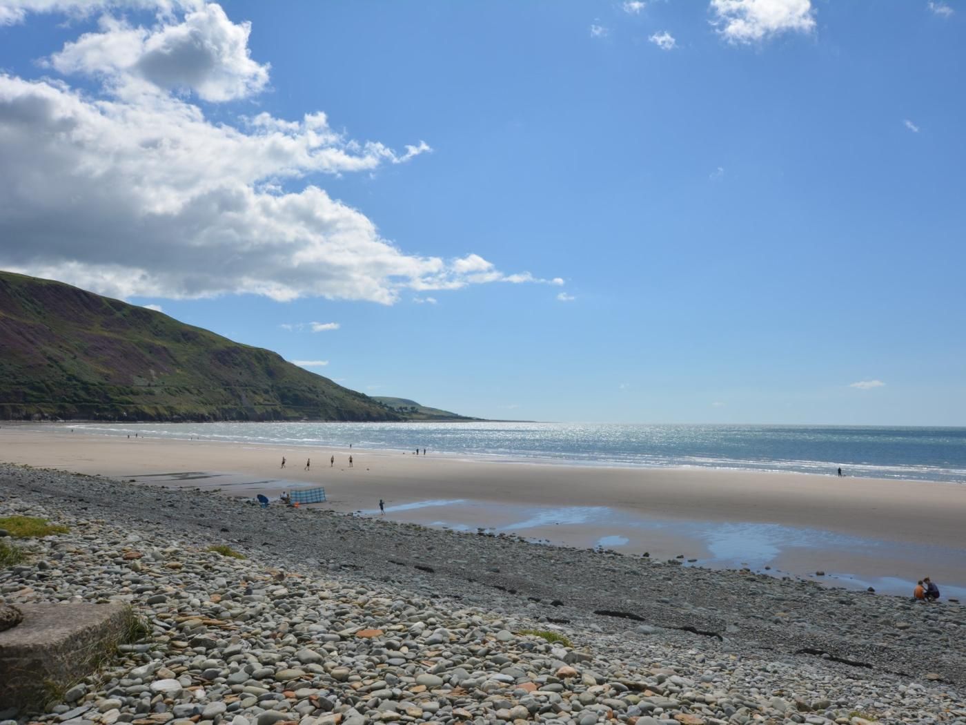 A beach with pebbles and a clear sky.