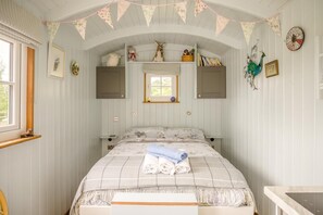 A room with a bed, a window, a clock, and a shelf with decorative items. - 1 Bed in Macclesfield (oc-58462) (Wincle)