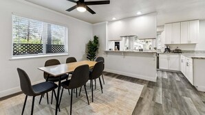 A modern kitchen with white cabinets, a granite countertop, and a ceiling fan. - 2543 Knox Avenue 3 Bedroom Cabin (South Lake Tahoe)