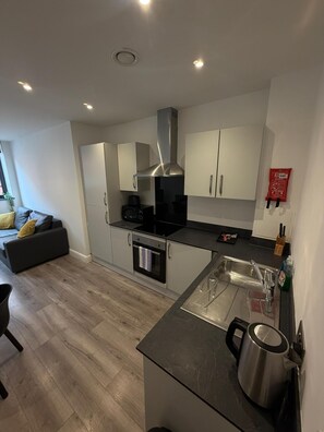 A modern kitchen with a built-in oven, a coffee machine, and a stainless steel kettle. - Dale Street Apartments by StaySavvy (Liverpool)