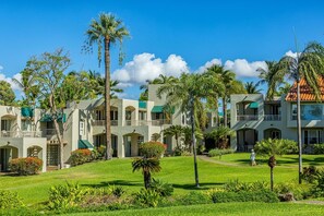 Ein Resort mit mehreren Gebäuden, Palmen und gepflegten Rasenflächen.