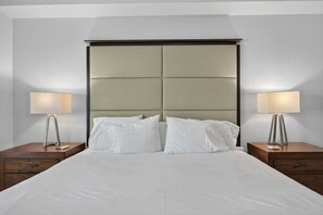 Ein Hotelzimmer mit einem großen Bett, zwei Nachttischen und zwei Lampen.