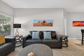 Ein modernes Wohnzimmer mit Sofa, Couchtisch und zwei Beistelltischen.